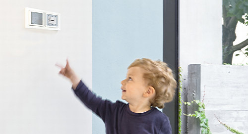 Kind zeigt auf in der Wand eingebautes Radio