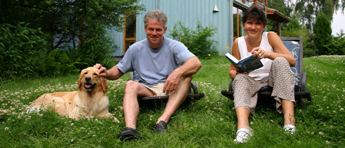 Mann, Frau und Hund auf dem Rasen hinter ihrem Haus
