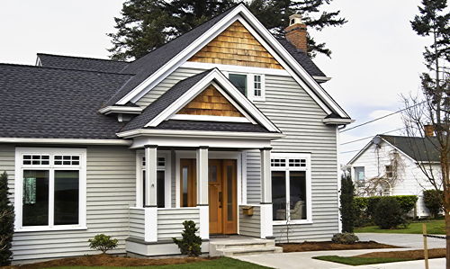 Haus mit grau gestrichener Holzfassade in Stülpschalung