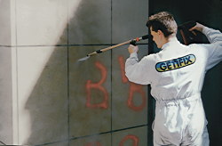 Mann beim Graffiti-Entfernen per Hochdruckreiniger