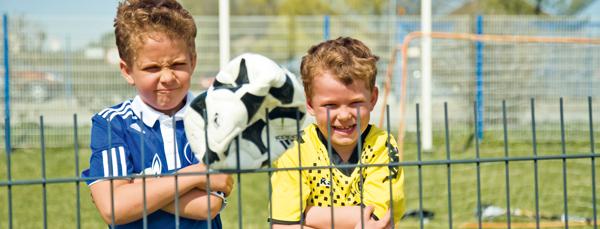 (Foto: Zwei Jungen am Zaun mit aufgespießtem Fußball) 
