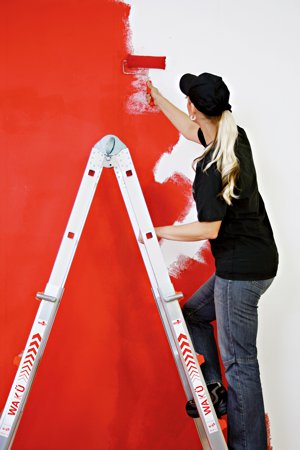 (Foto: Frau streicht eine Wand von der Leiter aus) 
