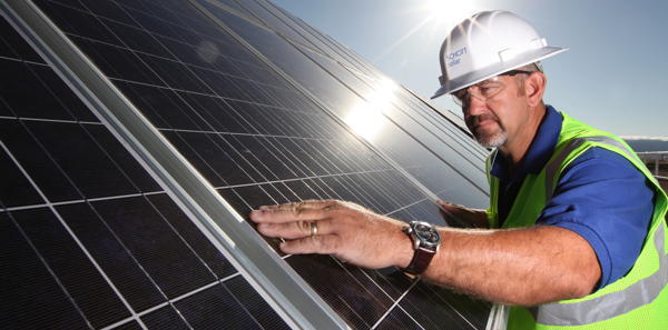 (Foto: Arbeiter mit Solarpaneelen) 