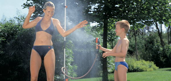 Foto: Gartendusche mit Frau in Bikini und Junge in Badehose