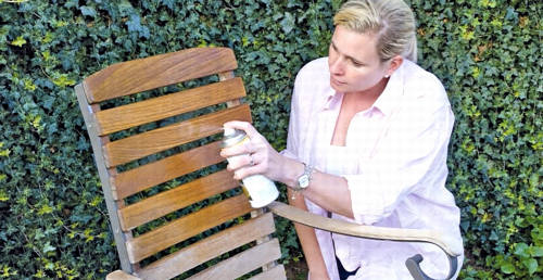Frau sprüht Spezialöl auf einen Gartenstuhl