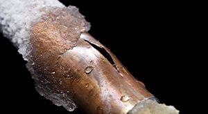 Eingefrorenes, geplatztes Kupferrohr mit längs verlaufendem Riss
