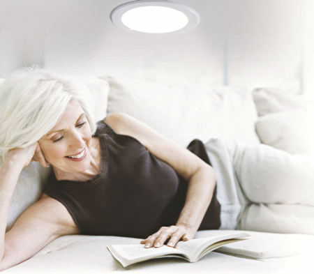 Lesende Frau unter Lichtauslass
