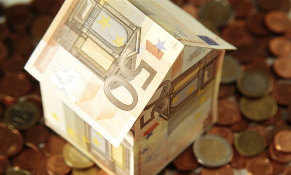 Symbolfoto: Haus aus Euro-Scheinen steht auf Münzen